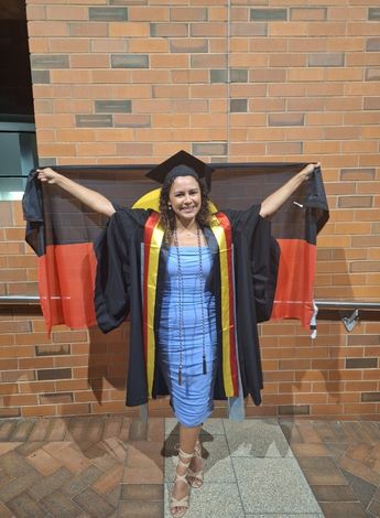 The photo is of Jasmin West at her university graduation, holding the Aboriginal flag. 